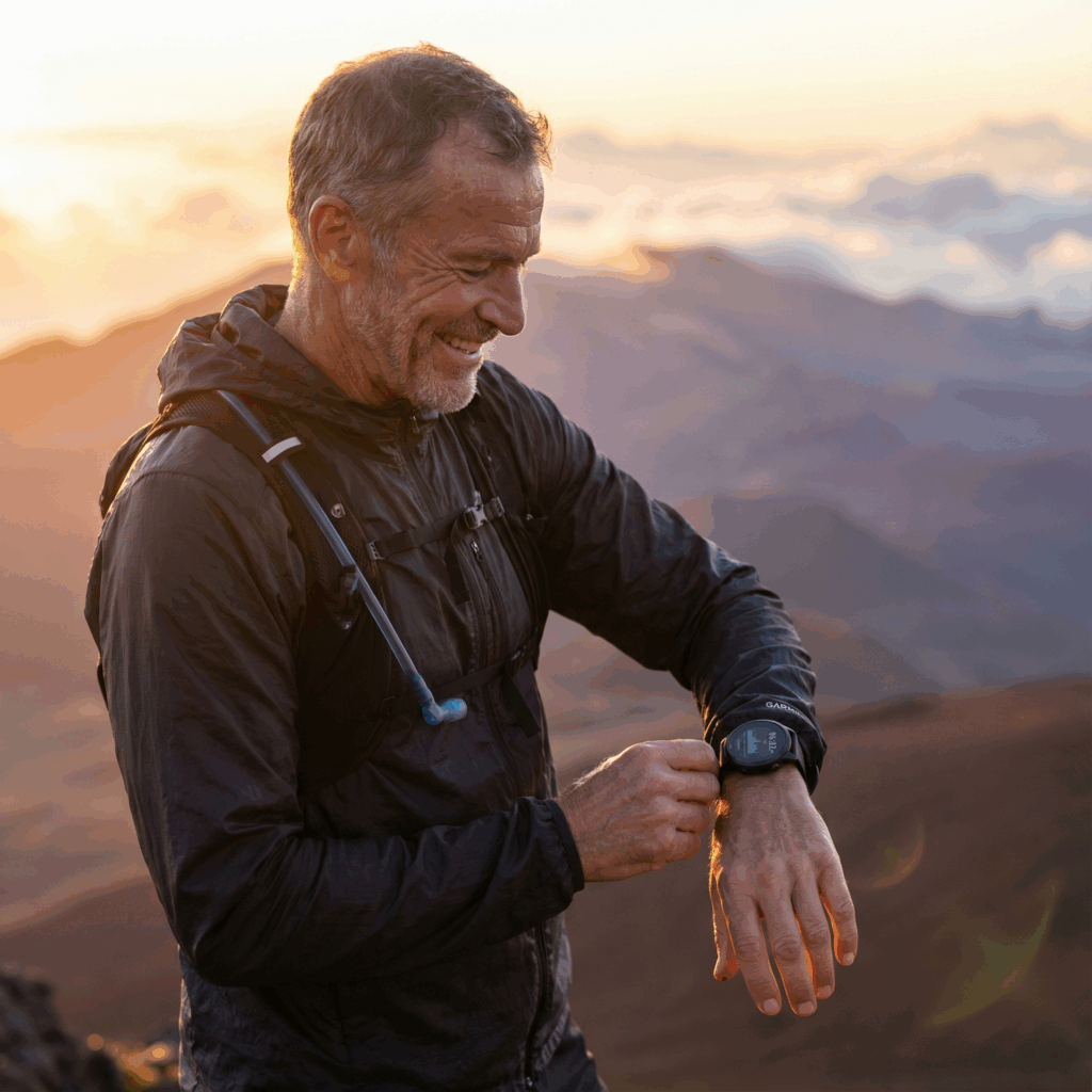 Trailrunner beim Checken seiner Garmin Fitness Daten. Symbolbild.